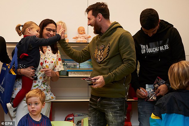 Barcelona legend Messi high-fived a little girl while Suarez signed an autograph behind him