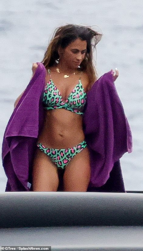 Holiday: Antonella topped up her bronzed tan in the two-piece and took a dip in the sea before later drying off with a bright purple towel