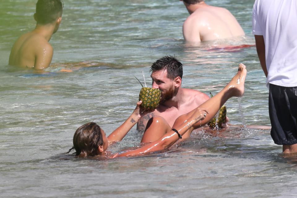  Antonella Roccuzzo held out a hollowed out pineapple for her husband to sip from